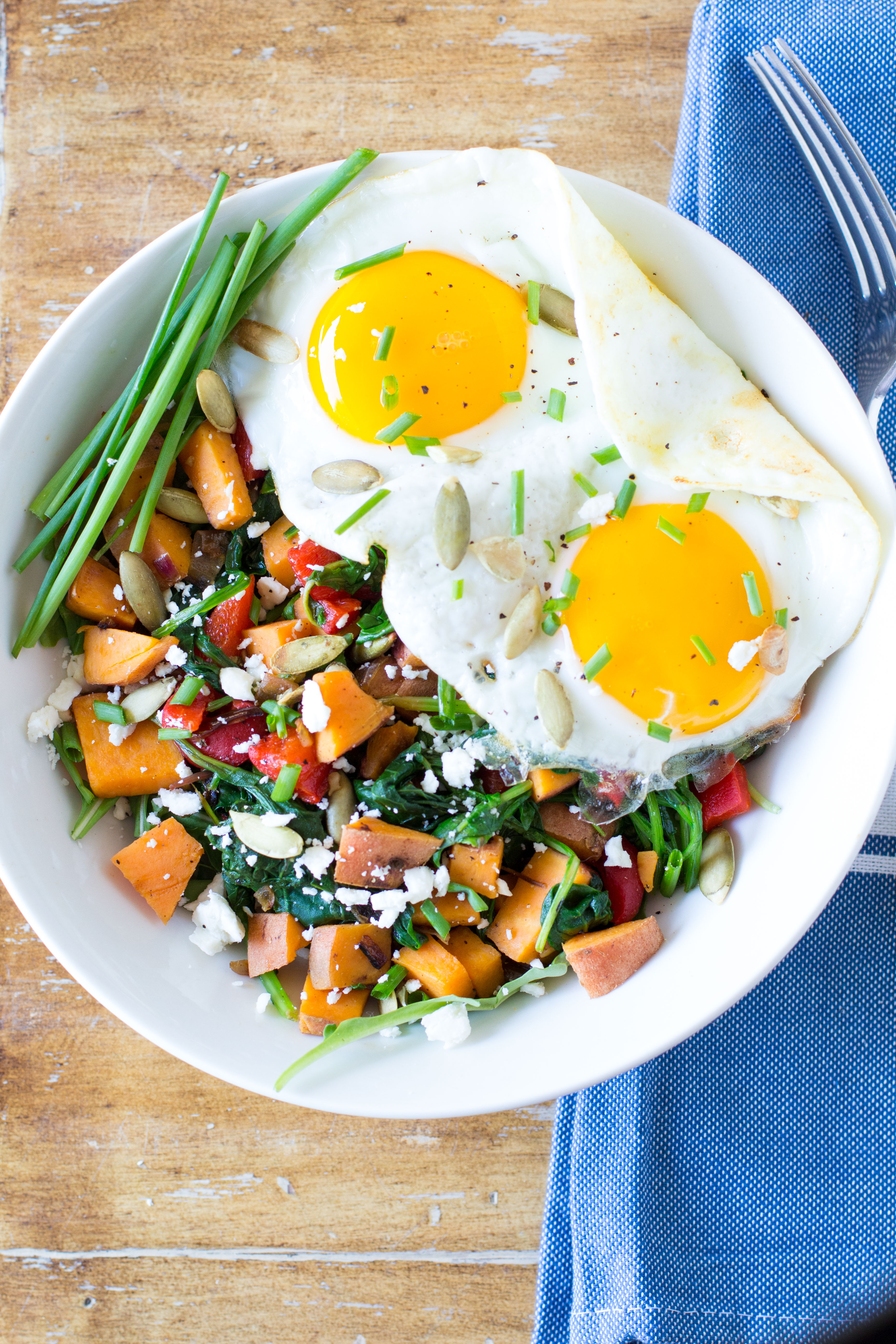 Start your day with a filling and nutritious breakfast bowl! Sweet potatoes, power greens, red pepper and onion add tons of fiber and vitamins, while fried eggs provide protein to keep you full until your next meal. 