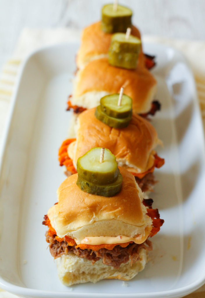 These pulled pork sliders are perfect to serve a large crowd on game day! Pressure cooked until tender and covered with a tangy and sweet barbecue sauce.