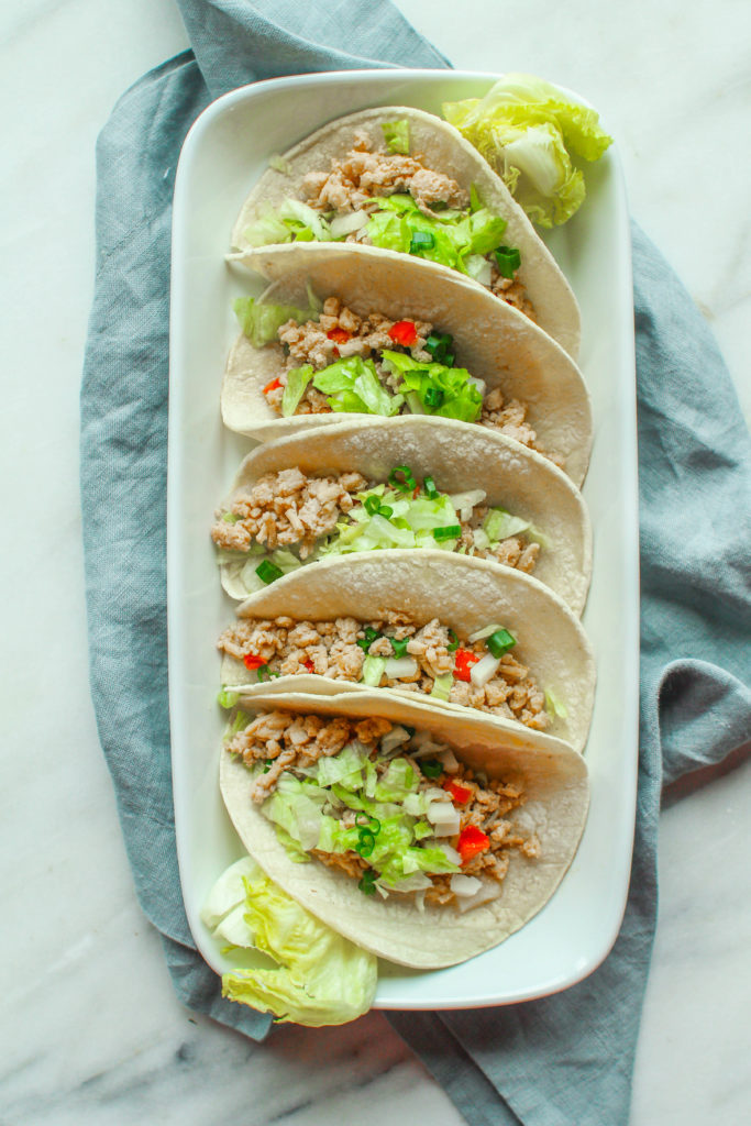 Savory and full of flavor, these Asian chicken tacos are made in the slow cooker and are packed with water chestnuts, brown rice, and topped with crunchy lettuce and green onion.  