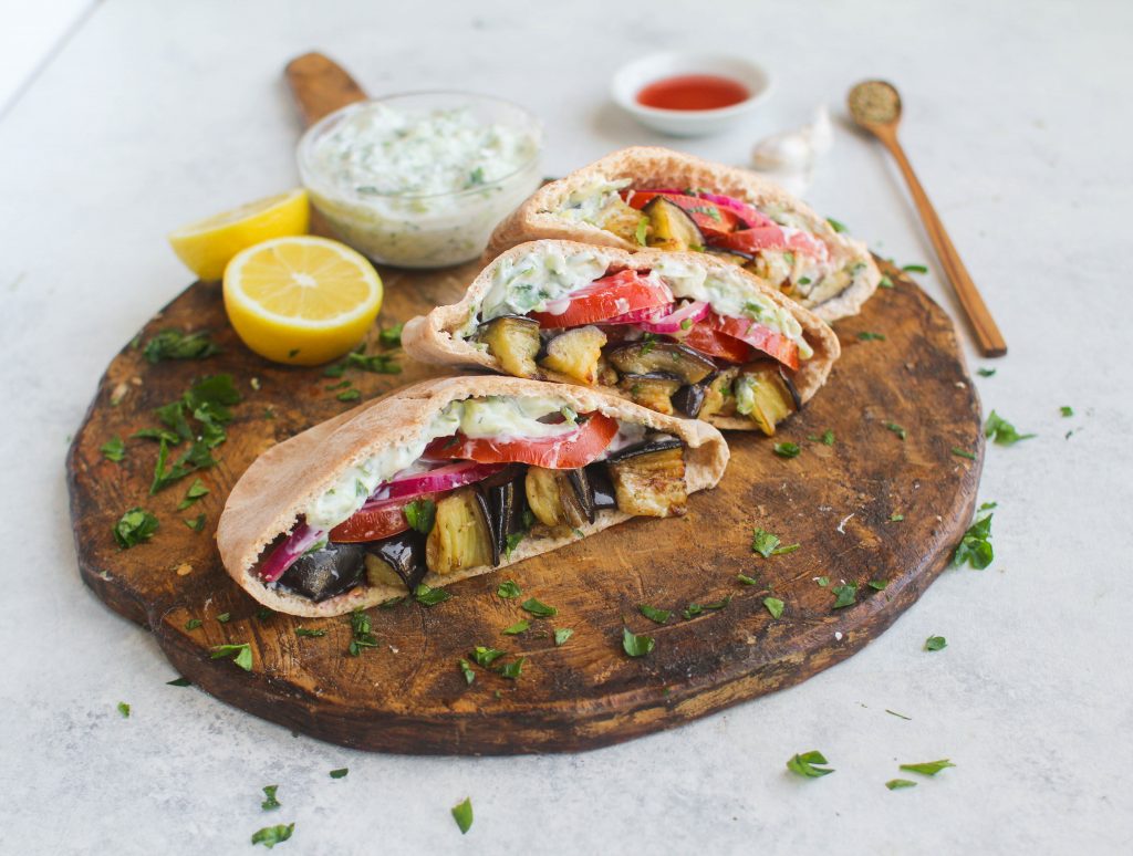 Roasted eggplant tossed in olive oil and oregano make the perfect base for these stuffed pitas! Piled high with tomatoes, pickled red onion, and dill tzatziki sauce. These roasted eggplant pitas are a delicious and vegetarian lunch option. 