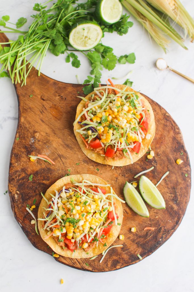 Enjoy a delicious plant based meal with these vegan Roasted Corn & Bean Tostadas! Fresh corn on the cob, roasted until brown in the oven and a creamy seasoned mashed pinto bean spread on top of a crunchy tostada shell. 