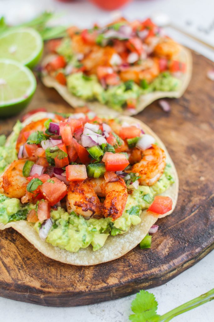 Shrimp marinated in spices and grilled until golden brown top these easy weeknight shrimp tostadas. Don't forget the guacamole and pico de gallo! 