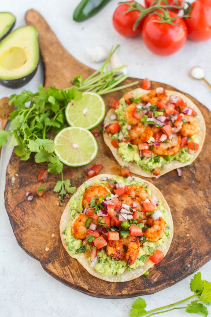 Shrimp marinated in spices and grilled until golden brown top these easy weeknight shrimp tostadas. Don't forget the guacamole and pico de gallo! 