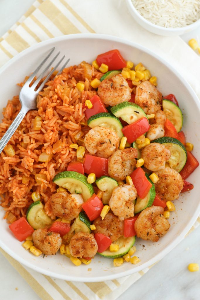 shrimp and veggies with rice in a bowl