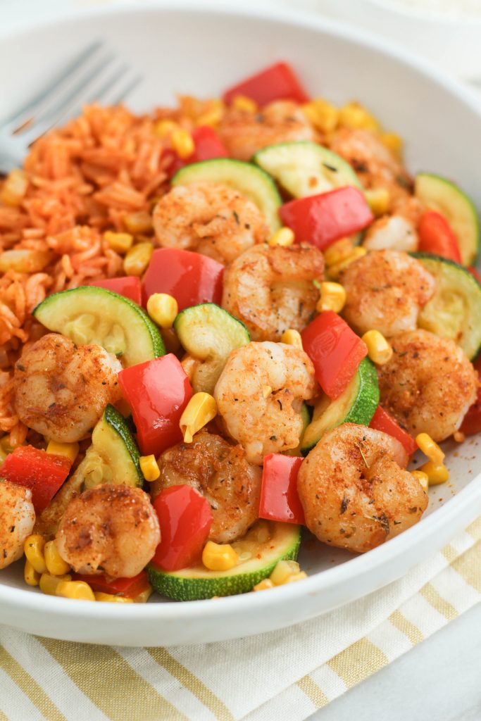 shrimp and veggies with rice in a bowl