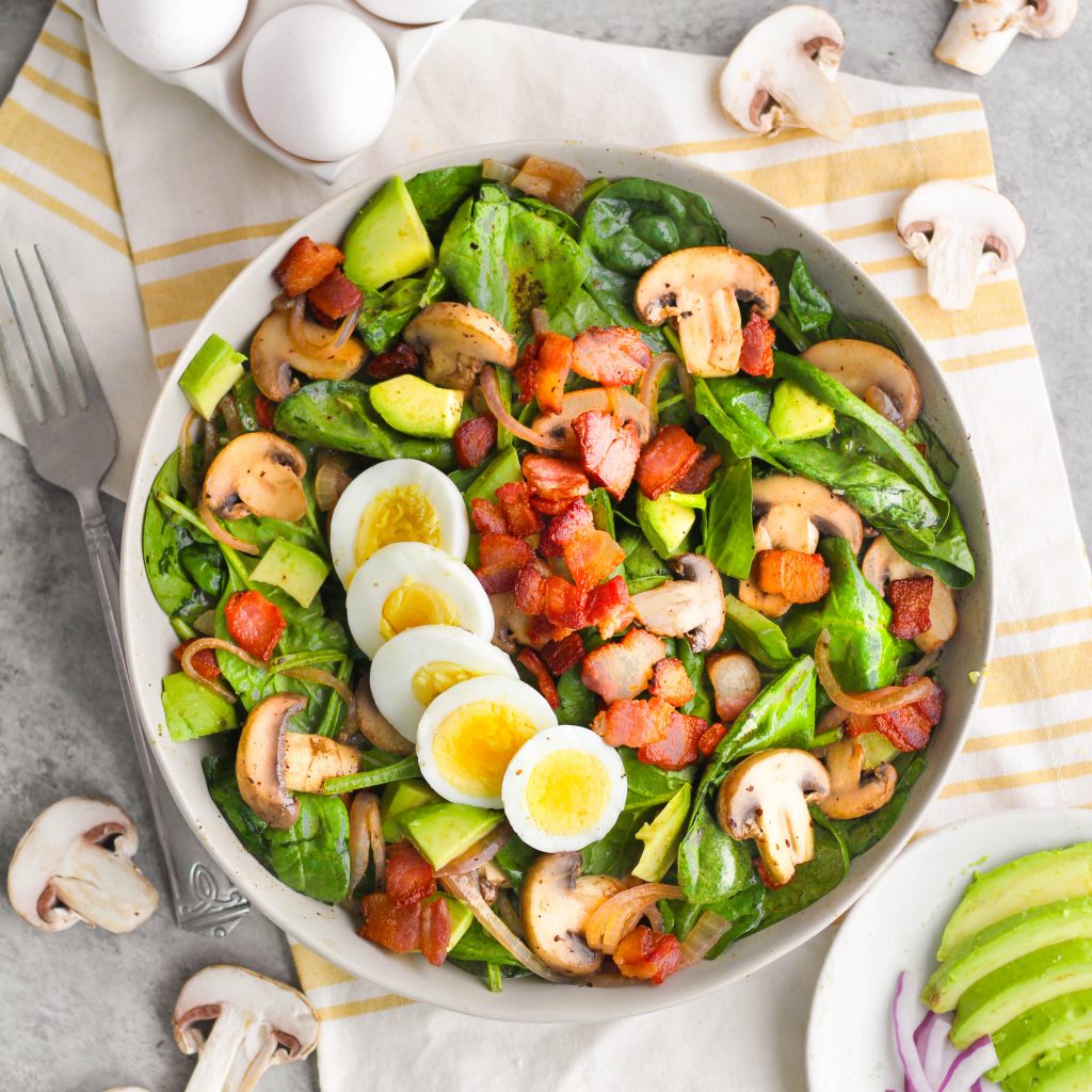 The combination of mushrooms, bacon, avocado, and salty hard-boiled egg is perfect when combined with a vinegar Dijon dressing made right in the skillet! This warm spinach salad is a delicious, easy, and hearty meal sure to fill you up and satisfy your taste buds.
