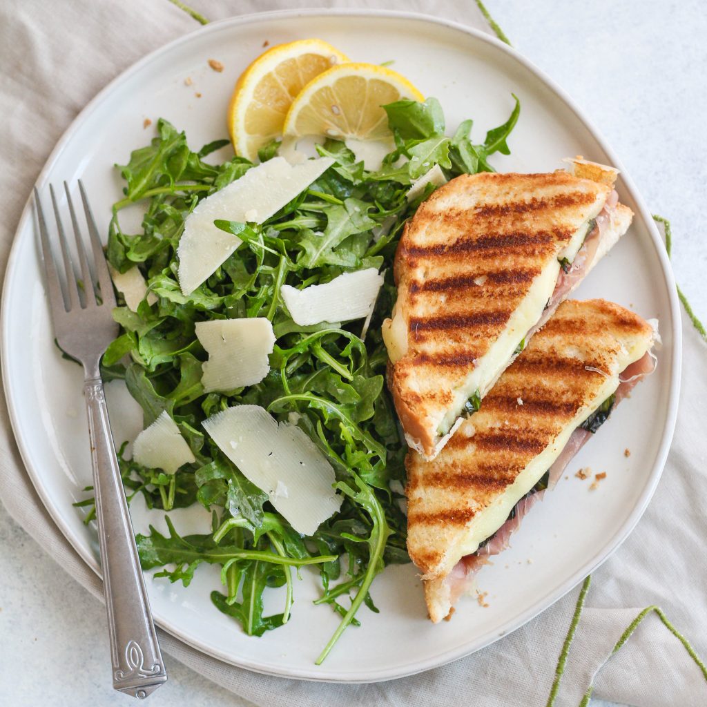 Elevate your grilled cheese with this savory mozzarella, basil, and prosciutto version! Served with a quick side salad of peppery arugula, salty Parmesan and lemon dressing.