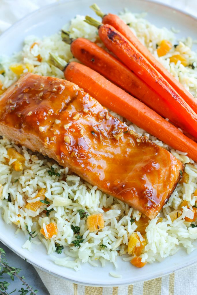 Fresh salmon topped with a homemade sweet and savory marinade consisting of fresh ginger, garlic, soy sauce, and apricot preserves. Served with a side of quick rice pilaf with dried apricots, slivered almonds, and fresh thyme, and roasted carrots.