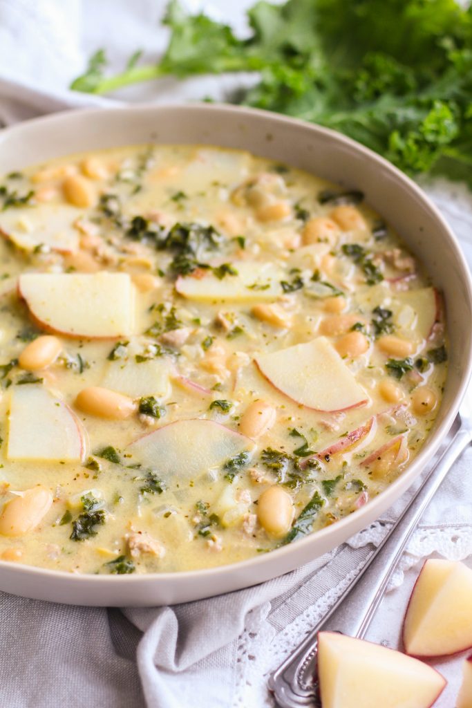 This traditional Zuppa Toscana, or Italian soup, is so easy to make at home with plenty of pantry staples! Pork sausage, thinly sliced potatoes, white beans, and kale simmered in broth until tender with plenty of Italian seasoning. 