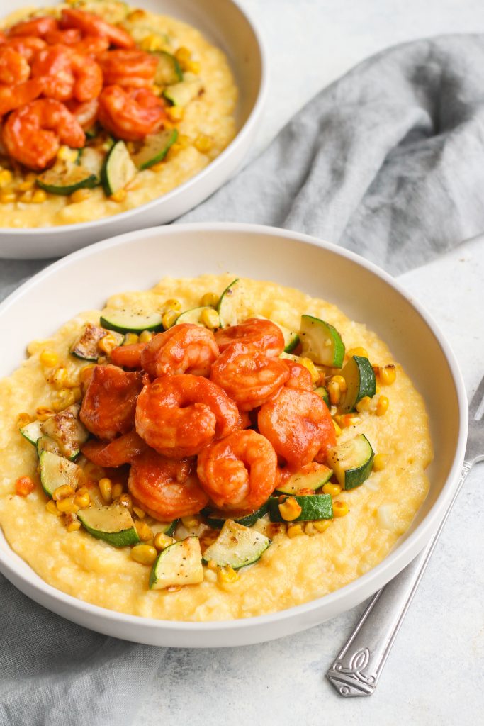 Cheddar cauliflower grits topped with sauteed summer veggies (corn, zucchini) and shrimp slathered in BBQ sauce. 